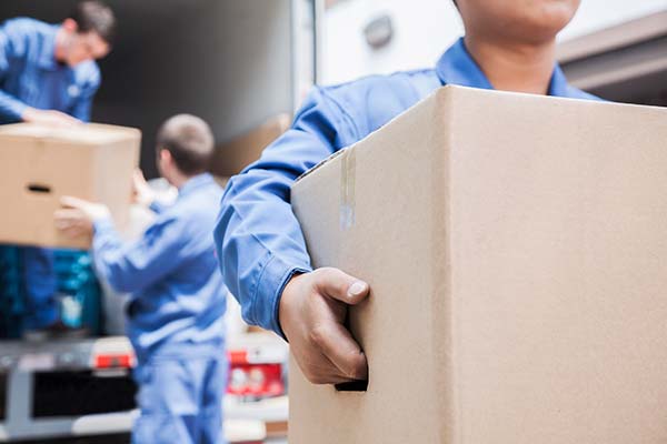 Couple lying on the floor surrounded by moving boxes after successful relocation
